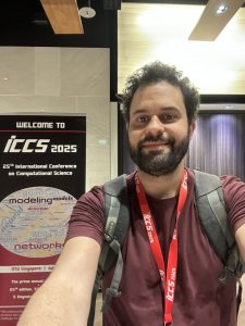 Prof. Ruy Freitas Reis em frente ao painel do evento ICCS 2025