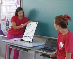 Professora e voluntária do projeto apresentando jogo