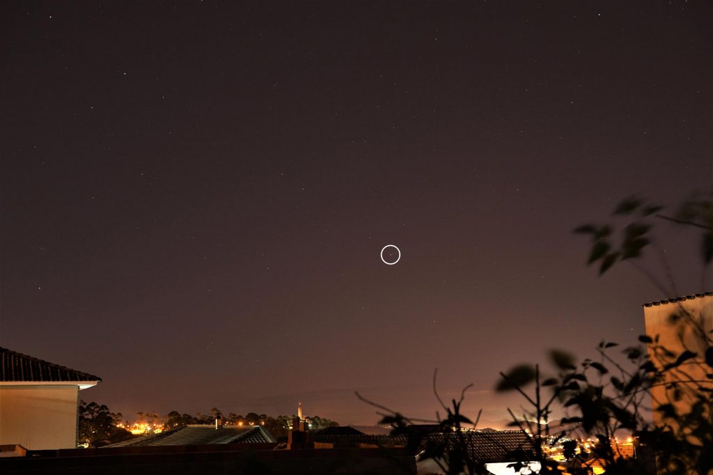 Foto do céu à noite com uma marcação indicando a posição do cometa Neowise.
