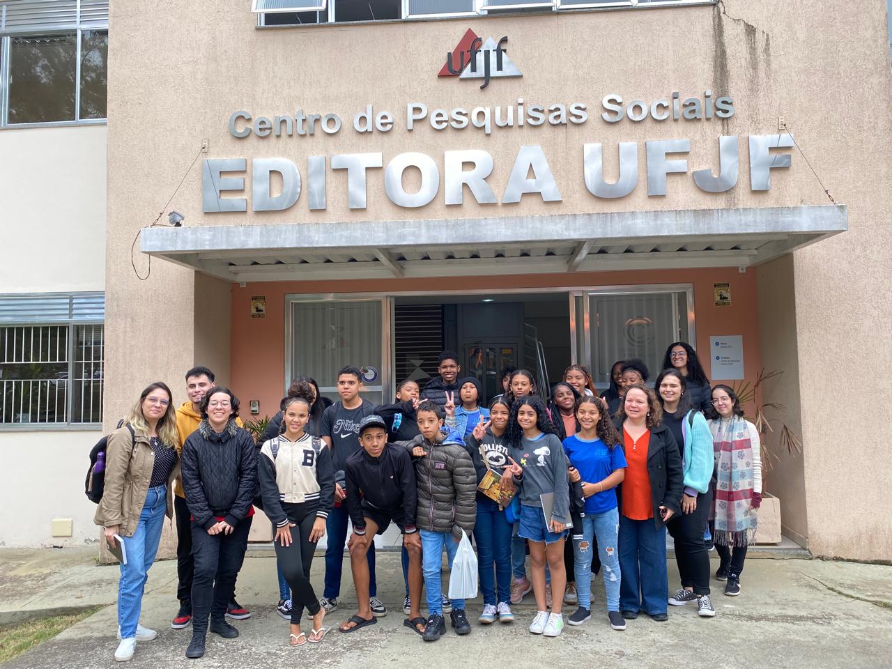 Alunos da Escola Municipal Santa Cecília junto com os membros da equipe do projeto na frente da Editora UFJF
