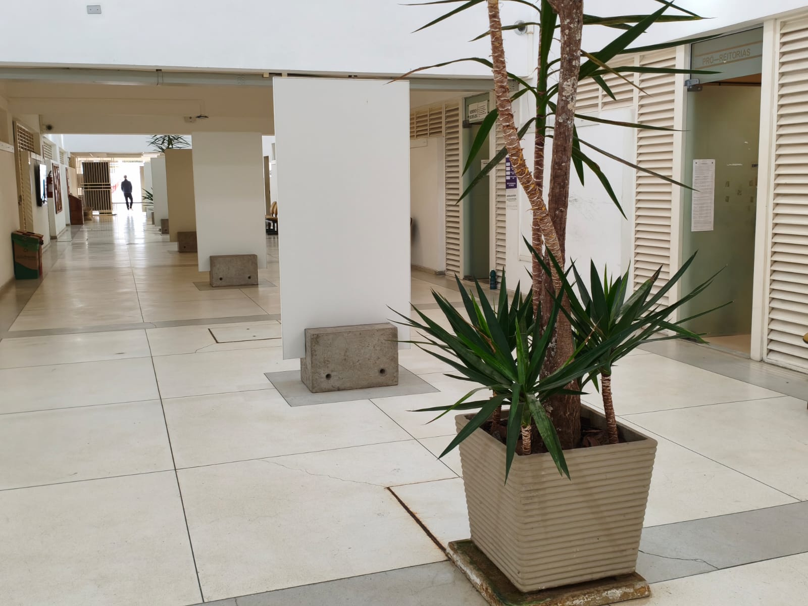 Galeria Helio Fádel, no corredor da Reitoria da UFJF. Possui painéis brancos sobre suportes de concreto..