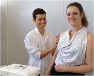 Foto de servidora recebendo a vacina na campanha.